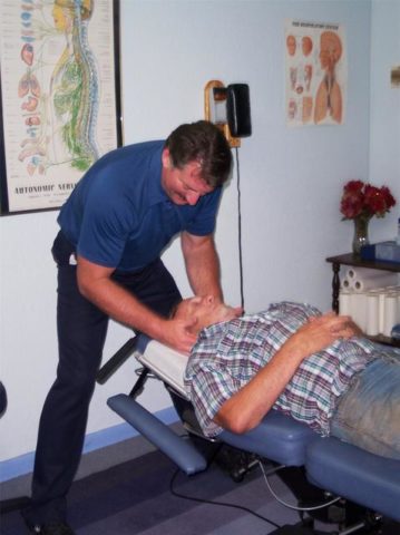 a chiropractor manipulating the neck of a patient with neck pain
