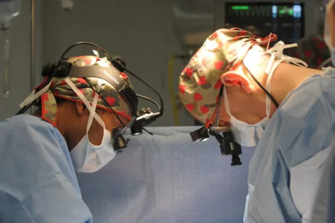 These doctors are in the operating room working on a heart stent procedure.