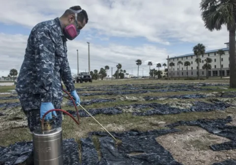 U.S. Navy applying permethrin spray to military uniforms