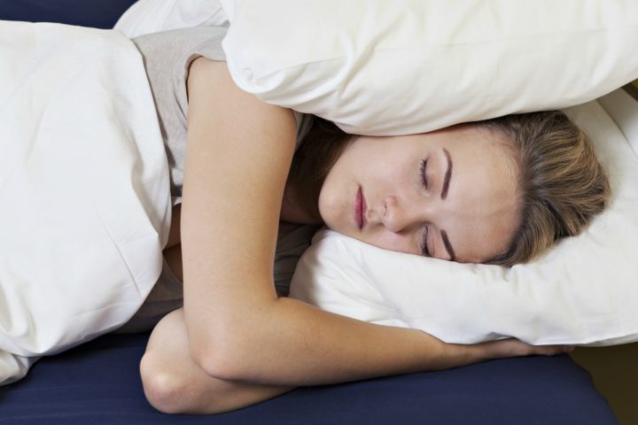 I've found that you can drown out noise while you sleep simply by placing a down pillow over each ear while sleeping on your side.